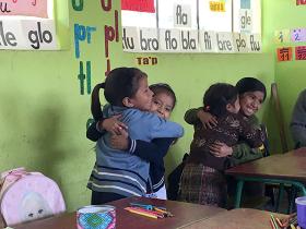 Students hugging in classroom in Guatemala